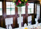 <p>Stół weselny z wysoką dekoracją kwiatową</p>